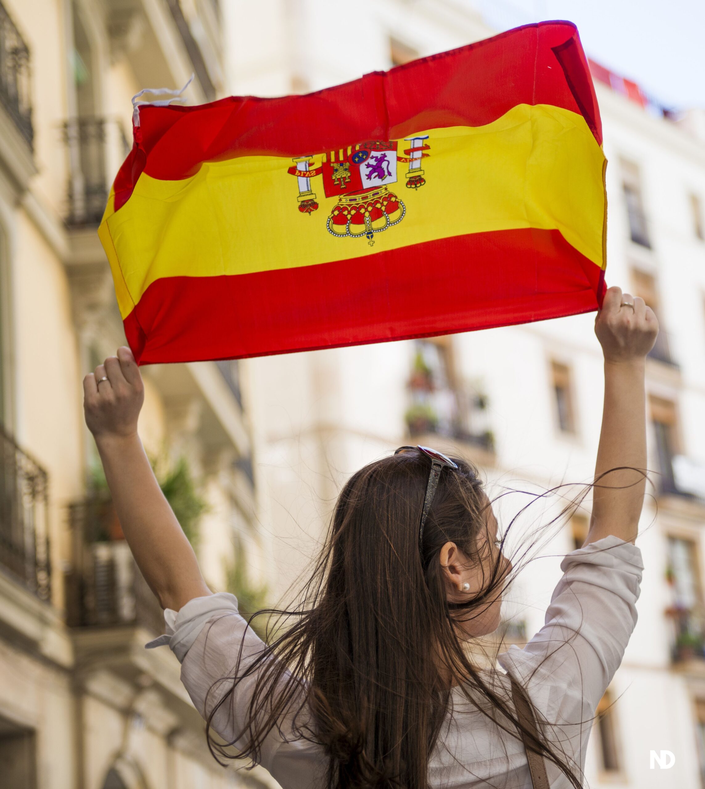 Mujer sostiene bandera españa nómada digital