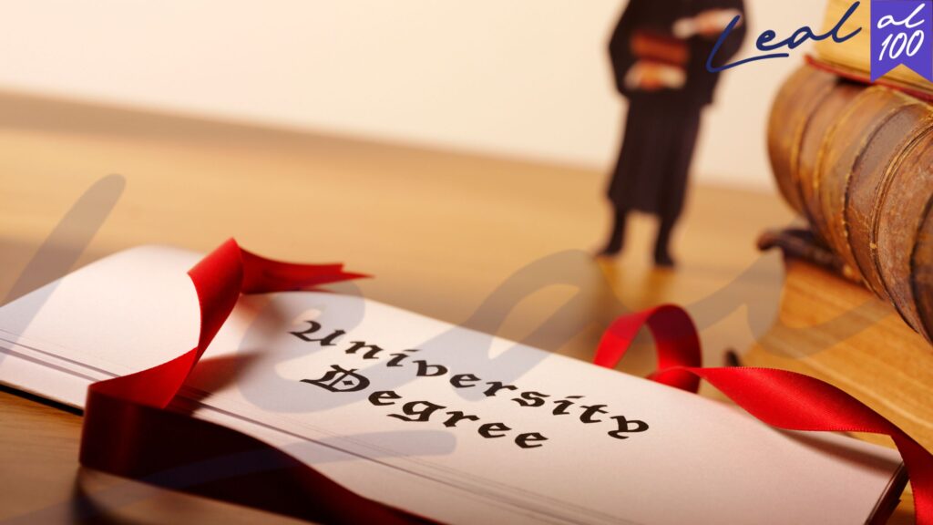 cartón universitario con lazo rojo, escríto en inglés, libros y persona de fondo, cómo obtener la visa de nómada digital en españa